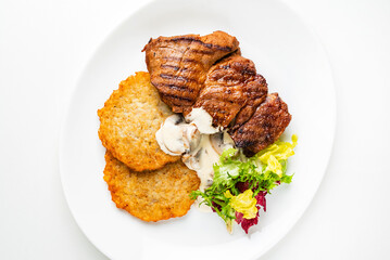 pork steak with potato pancakes and salad