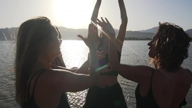handsome females hands dancing friendship in sea at sunset slow motion