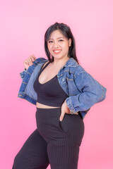 Portrait beautiful plump young woman smiling on pink background , plus size fashion model body positive concept