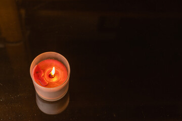 High angle shot of a lighted candle with smoke on crystal glass