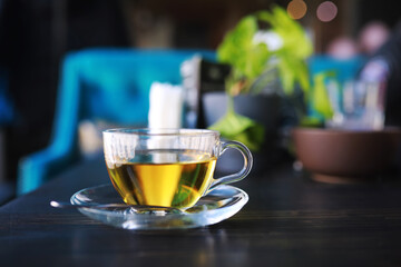 Hot steaming green tea in a cup on a rustic background