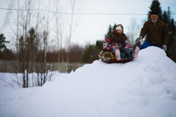 Traditional Russian holiday in early spring. Seeing off winter. Mardi gras. Family with children in the winter in the park.