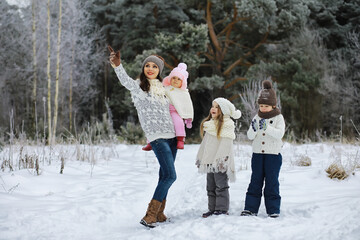 Happy family playing and laughing in winter outdoors in the snow. City park winter day.