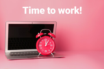 Alarm clock and laptop on color background with text TIME TO WORK