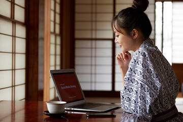 旅館でワーケーションする浴衣姿の若い女性