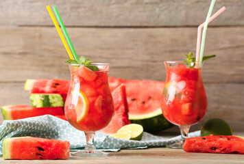 Glasses of tasty cold watermelon lemonade on wooden table