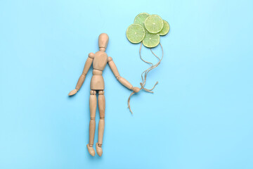 Composition with wooden human mannequin and lime slices on color background