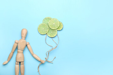 Composition with wooden human mannequin and lime slices on color background