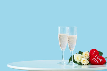 Glasses of champagne and flowers on table. Valentine's Day celebration