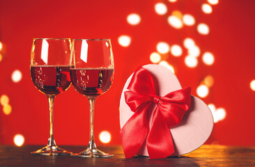 Glasses of wine and gift for Valentine's Day on table