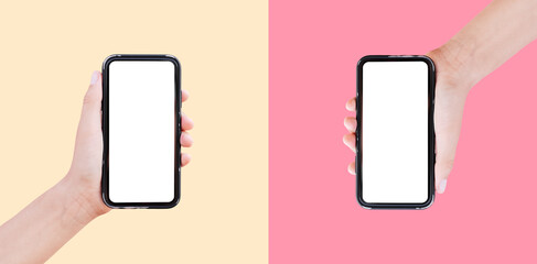 Close-up of two smartphones in hands on backgrounds of pastel yellow and pink of colors.