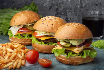 Three burgers with French fries. Burgers with beef patty.