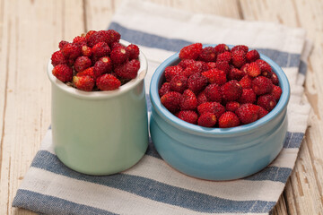 Fresh bilberries and strawberries in blue bowls, healthy eating concept