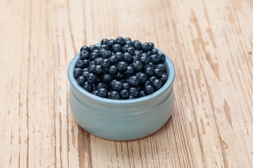Blueberries on white vintage wooden background, organic food concept