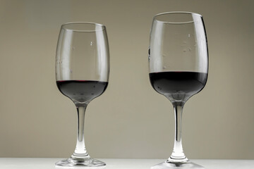 Two glasses of red wine on a blurred homogeneous background. Horizontal photo