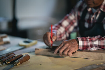 Fototapeta na wymiar Carpenter working on wood in carpentry shop. the man works in a carpentry shop