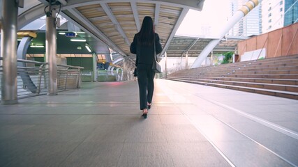 Back side of smart Business woman is walking on city street , business people ...