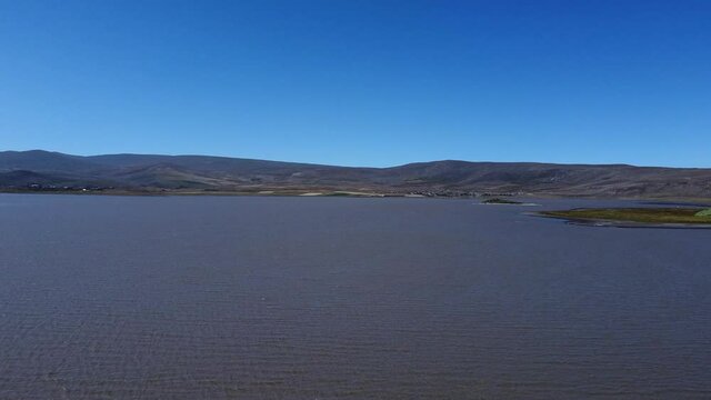 Aerial Drone shot of Mountain Lake with slow passing shore
