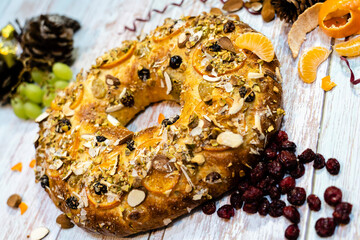roscon de reyes traditional Spanish dessert made at Christmas with almond cream and candied fruit with rustic background	