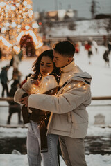 Young romantic couple in love outdoors in winter before Christmas.  Two lovers are hugging and kissing in Saint Valentine's Day.