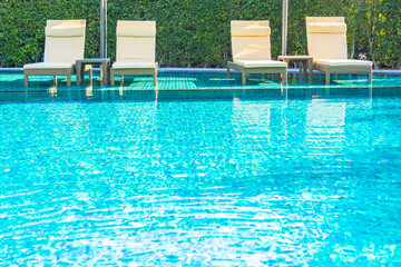 Umbrella and chair around outdoor swimming pool