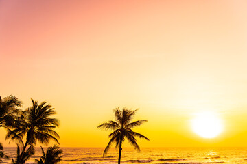 Fototapeta na wymiar Beautiful tropical beach sea ocean at sunrise or sunset with palm tree