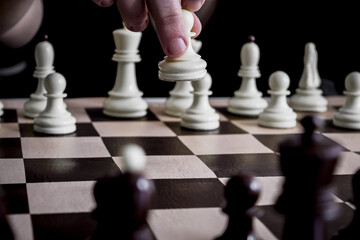Hand playing chess with white pi