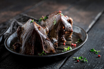Roasted pigeons with pepper on dark table