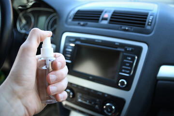 Cleansing car interior and spraying with disinfection liquid. Disinfection of the steering wheel and handles of the car. Coronavirus protection. Virus protection .Disinfecting vihicle inside