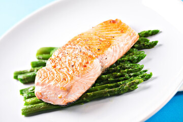 Fillet of salmon with asparagus on a plate.
