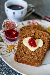 Heart shaped butter with jam on a slice of bread