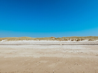 View over wide sand dunes at the beach, sunny day in summer, blue sky