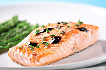 Fillet of salmon with asparagus on a plate.
