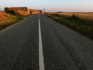 Road through the fields with a small village in the background