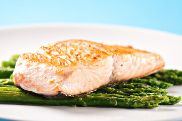 Fillet of salmon with asparagus on a plate.