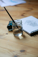 Closeup of watercolor or ink painting, minimalistic designer desk	
