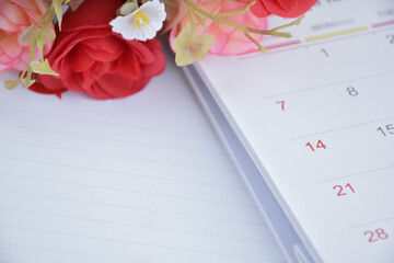 White desk calendar of February with rose flower, concept for valentines day on 14th February 2021.