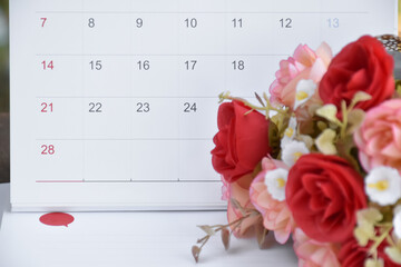 White desk calendar of February with rose flower, concept for valentines day on 14th February 2021.