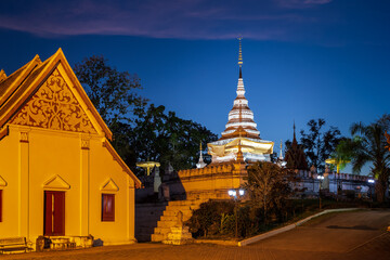 Naklejka premium Golden pagoda and chapel on hill or mountain to at Wat Phrathat Khao Noi temple during twilight, Nan province, Thailand