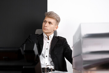 Pensive man sitting at table thinking about problem solution, thoughtful male employee pondering on idea, looking away, making decision