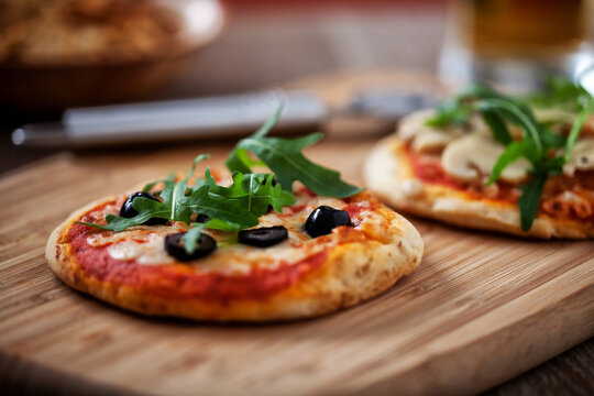 Mini Pizzas served on Wooden Board. High quality photo.