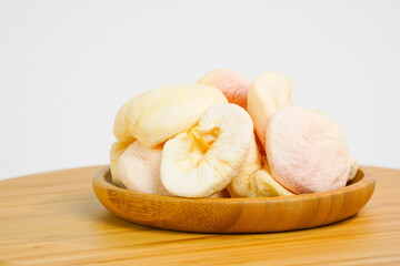 Sun-dried fruits in wooden bow isolated on white. Dried apples on white background. Copy space. Naturally dried white apple.  Product for sale.  Studio photo.