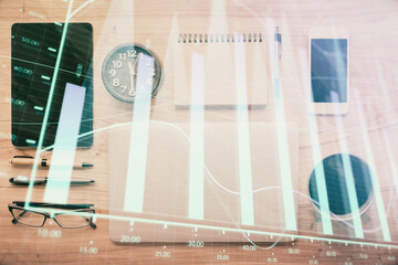 Double exposure of forex graph hologram over desktop with phone. Top view. Mobile trade platform concept.