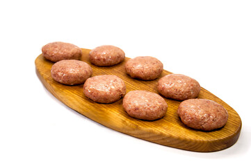 raw minced meatballs on a wooden board isolated on white