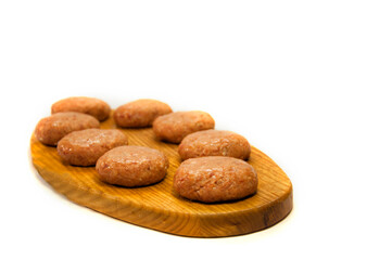 Fototapeta premium raw minced meatballs on a wooden board isolated on white