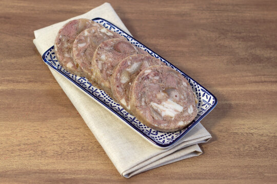 Homemade brawn headcheese meat product saltison on rough linen cloth with sea salt and spices