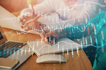 Double exposure of forex chart drawing over people taking notes background. Concept of financial...