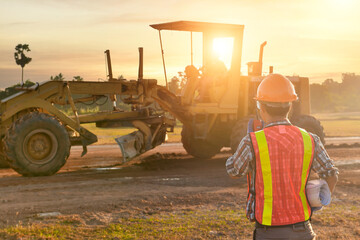 Engineers are working on road construction. engineer holdingradio communication at road...