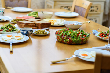 Serving of eggs, bread and salad from fresh vegetables on wooden table, healthy and organic food, breakfast with friends