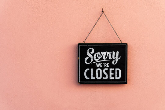Sorry we're closed sign.  image hanging on in pink wall